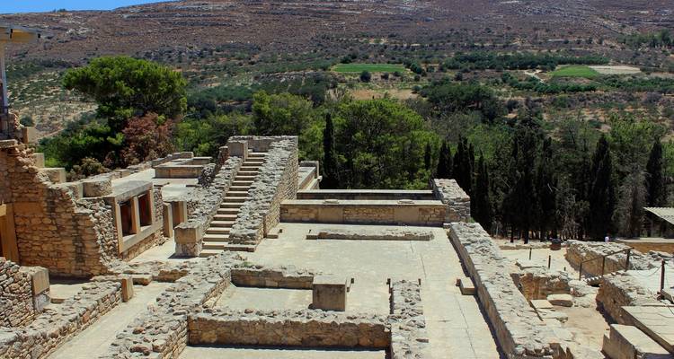 Wide view of archaeological terraces and dry landscape at the ancient ruins of Knossos.