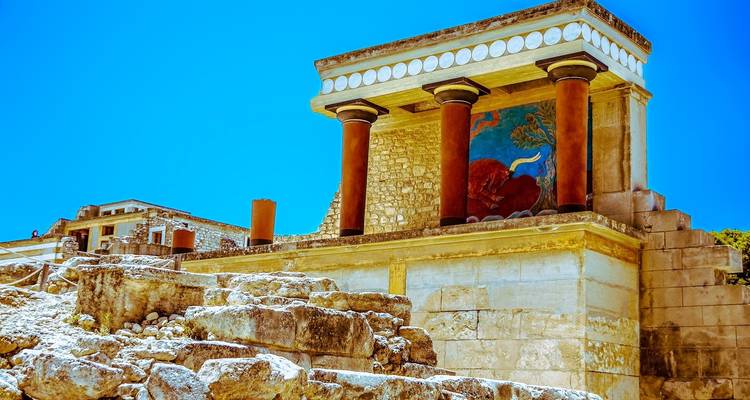 Restored frescoed columns of the ancient Knossos Palace glint under bright Cretan sunshine.