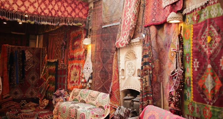 Interieur van een traditionele Turkse tapijtwinkel met levendige gepatroneerde tapijten gedrapeerd over muren en banken.