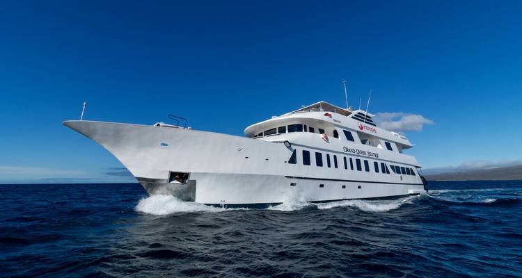 Eine große weiße Kreuzfahrtyacht, die durch das Meerwasser schneidet.