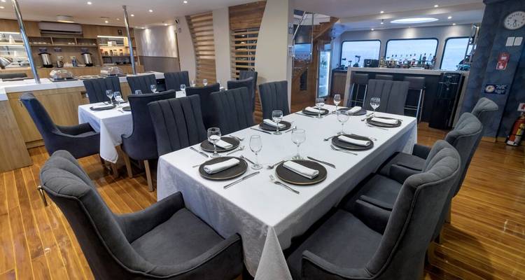 Essbereich in einer Yacht mit einem für eine Mahlzeit gedeckten Tisch.