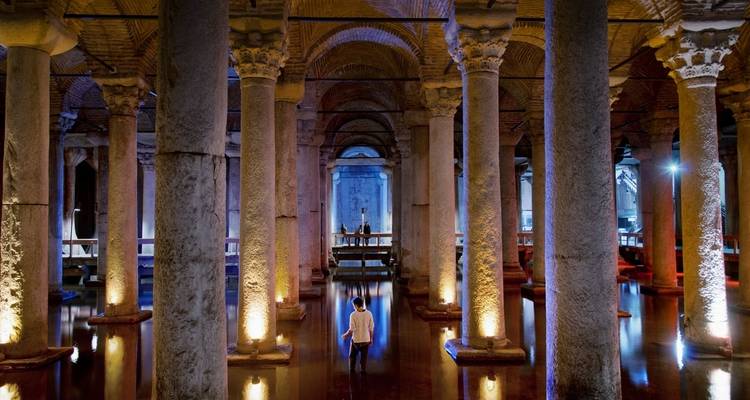 Vista interior de una cisterna subterránea histórica con columnas y arcos.