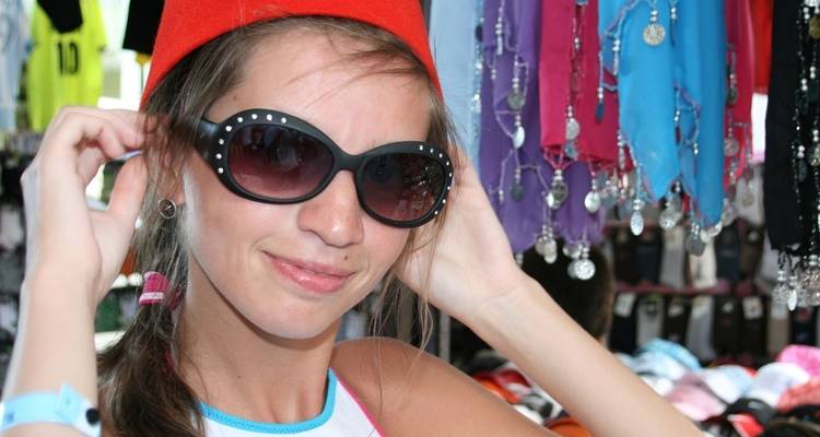 Jeune femme portant des lunettes de soleil et un chapeau traditionnel.