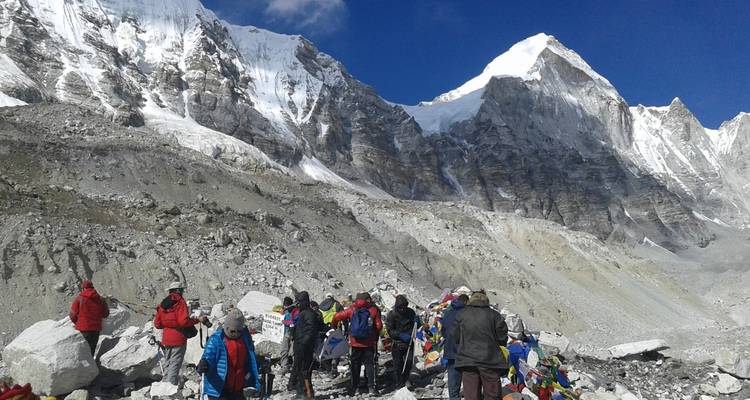 Trekkeurs au camp de base de l'Everest avec des drapeaux de prière.