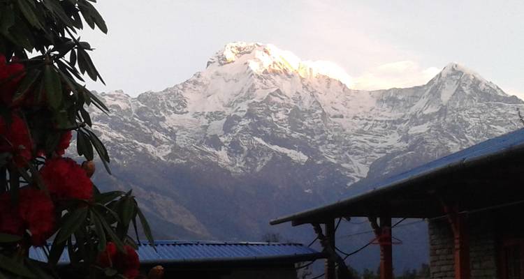 Berguitzicht met besneeuwde toppen en een dorp op de voorgrond.