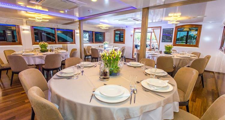 Comedor de yate con mesas bellamente arregladas.