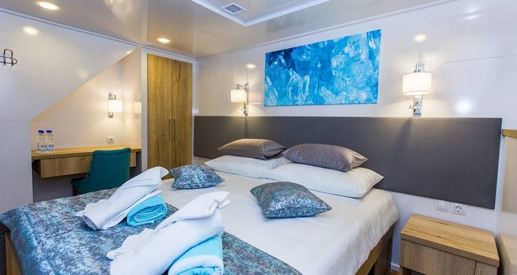 Dormitorio moderno de yate con arte y mobiliario.