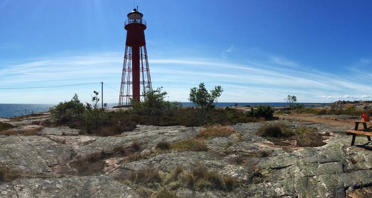 Phare sur un rivage rocheux sous un ciel bleu.