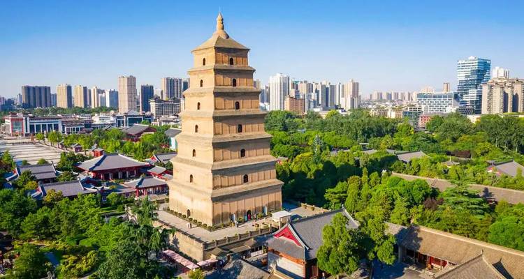 Luchtfoto van de Giant Wild Goose Pagoda die uittorent boven groene parken en het Xi'an stadslandschap onder heldere hemel.