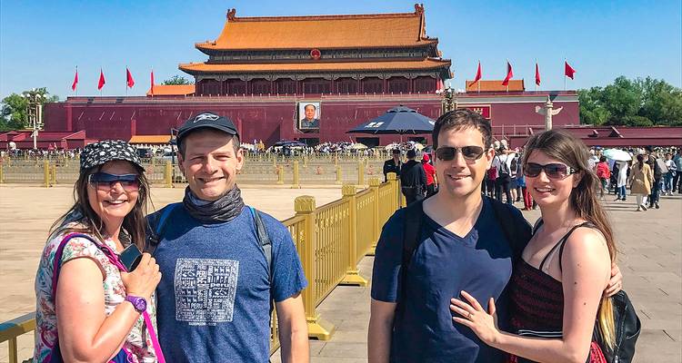 Four people posing with Tiananmen Gate in the background.