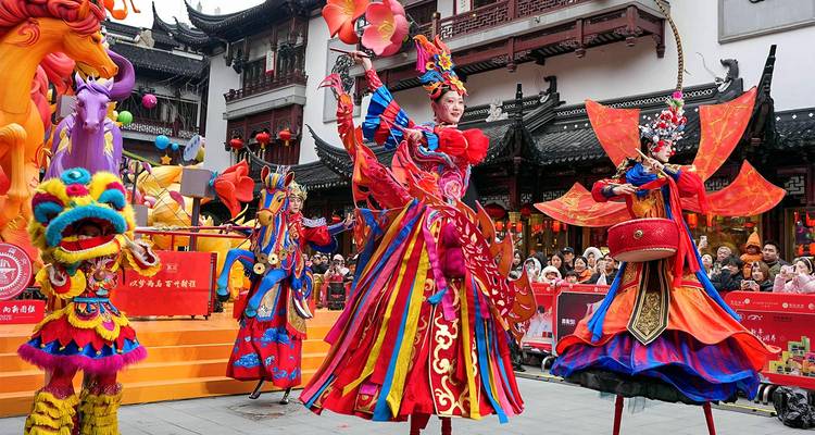 Colorful stilt dancers perform a festive show in a traditional Chinese courtyard while crowds watch.