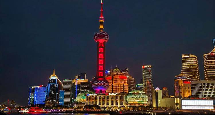 Skyline de Shanghai la nuit mettant en vedette la Tour de la Perle orientale illuminée et les gratte-ciel environnants.