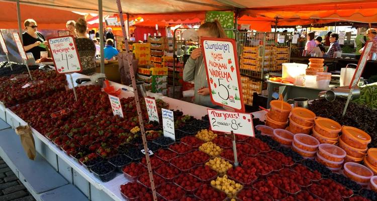 Outdoor market stall with various fruits and products on display.