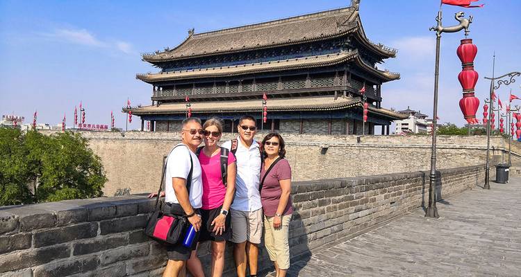 Group of tourists posing on an ancient city wall.