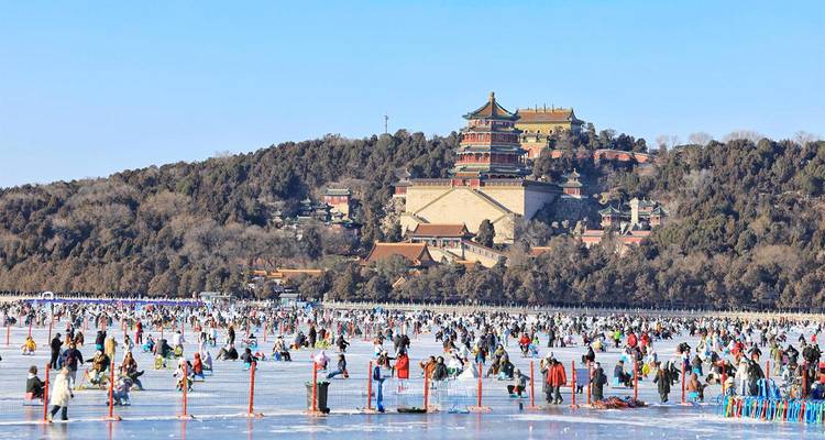 Honderden schaatsers glijden over het bevroren meer van Beijings Zomerpaleis met de pagode op de heuvel die erachter uittorent.