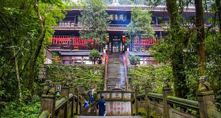 Mountain temple complex surrounded by lush vegetation, incense smoke drifting up stone steps.