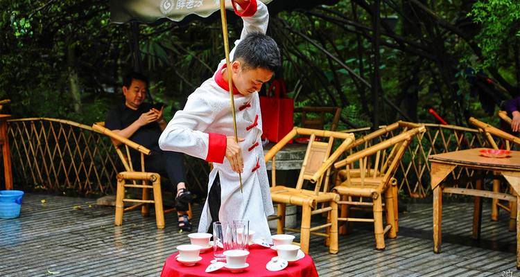 Traditional tea master gracefully pours tea from a long-spouted kettle into cups on a small table in a leafy teahouse.