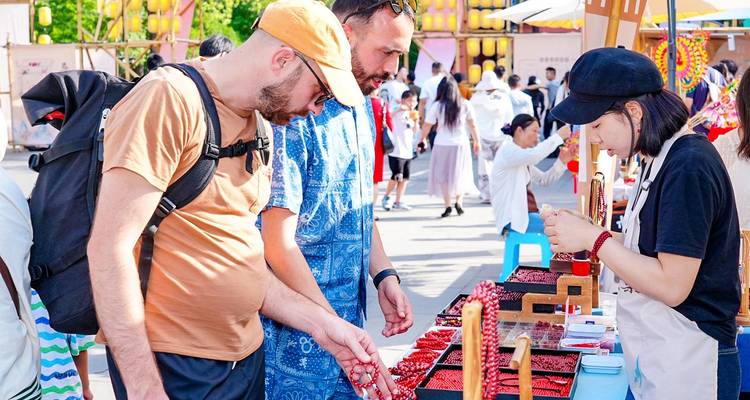 Visitors browse handcrafted goods at a busy outdoor market stall.