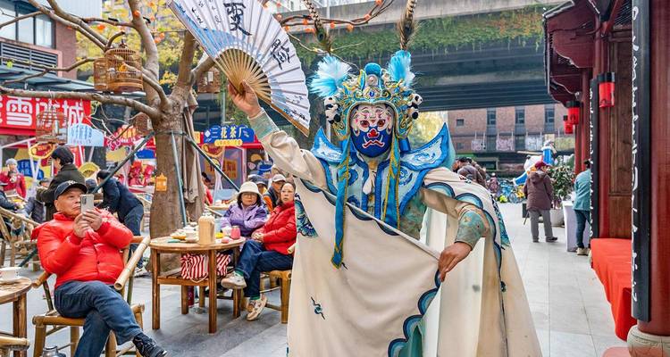 Vibrant face-changing opera performer brandishes a fan amid bustling street diners.