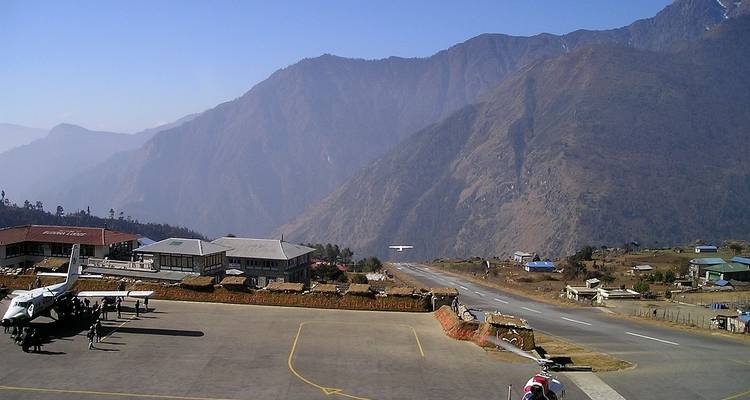 Small airport runway surrounded by mountains.