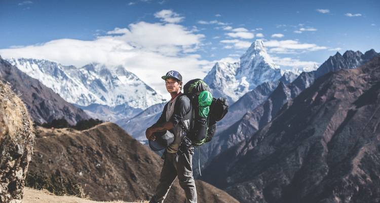Randonneur avec sac à dos dans l'Himalaya avec des sommets enneigés.