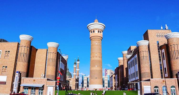 Grote Bazaar moskee-stijl toren en baksteencomplex onder een helder blauwe Xinjiang-lucht.