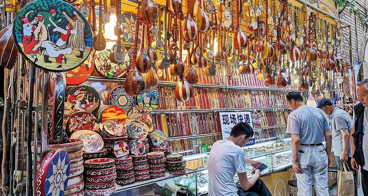 Drukke bazaarstand met rijen traditionele snaarinstrumenten en souvenirs.