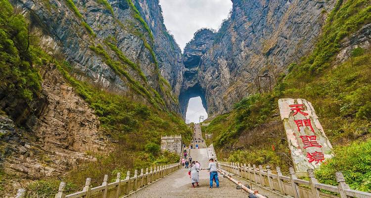 Long stone stairway leading to the dramatic Tianmen Cave portal carved into a towering cliff
