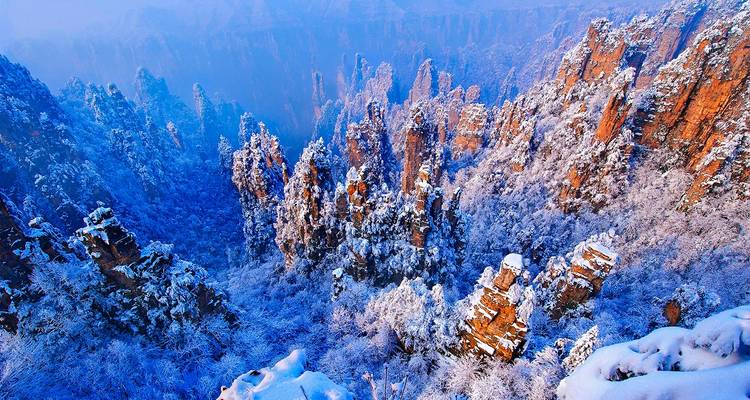 Snow-draped sandstone pillars and frosted trees forming a magical winter landscape