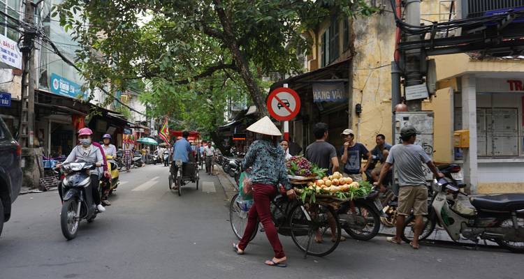 Busy street market with various vendors and shoppers.