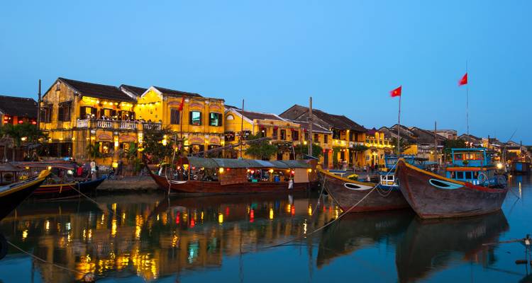 Colorful riverside buildings with boats moored in the water.