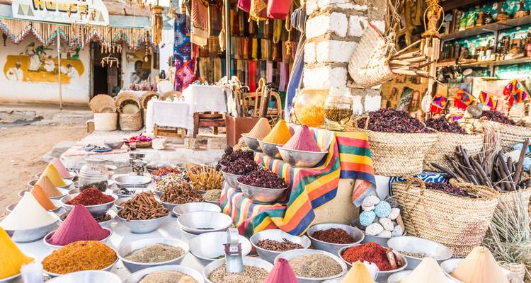 Étal de marché coloré avec un assortiment d'épices et de marchandises en exposition.