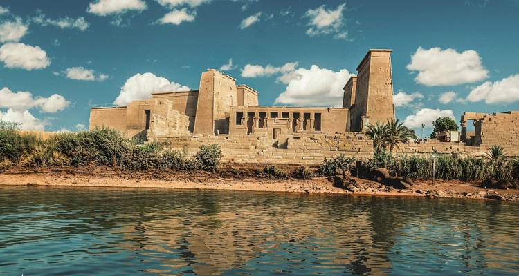 Oude tempel aan de rivier met weelderige omgeving.