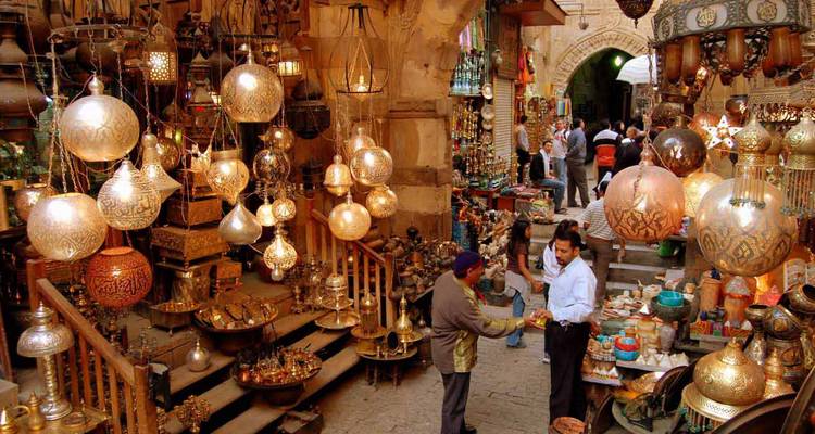 Belebter Markt mit traditionellen ägyptischen Laternen und historischem Ambiente.