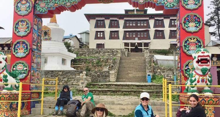 Group of tourists at a monastery with bright colors.