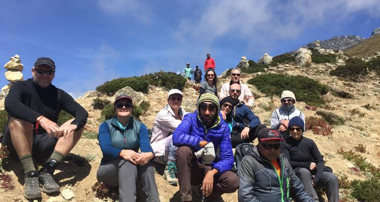 Group of trekkers resting on a hillside.