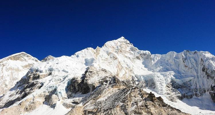 Majestic snow-covered mountains against a clear blue sky.