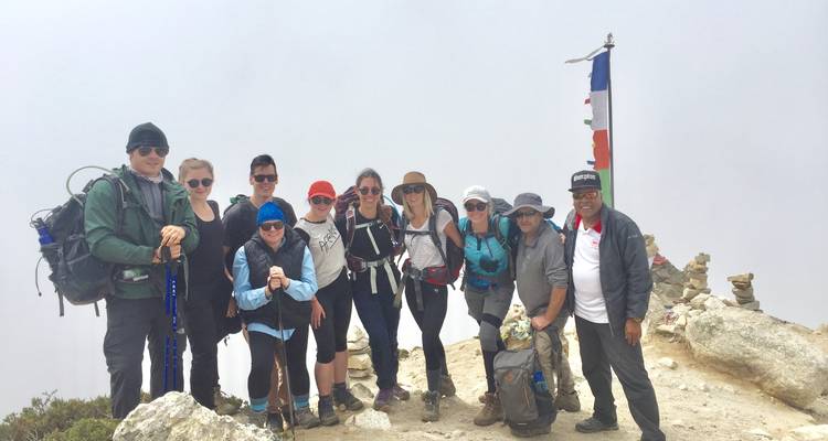 Group of trekkers posing with a white sky background.