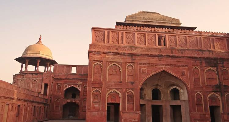 A historic red sandstone building with intricate carvings.