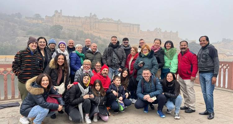 Foto grupal de turistas con un fuerte histórico de fondo.