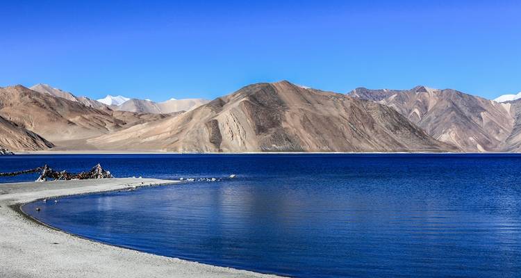 Une vue panoramique d'un lac pristine entouré de montagnes.