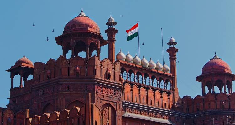 Fuerte rojo histórico con bandera india y palomas en vuelo.