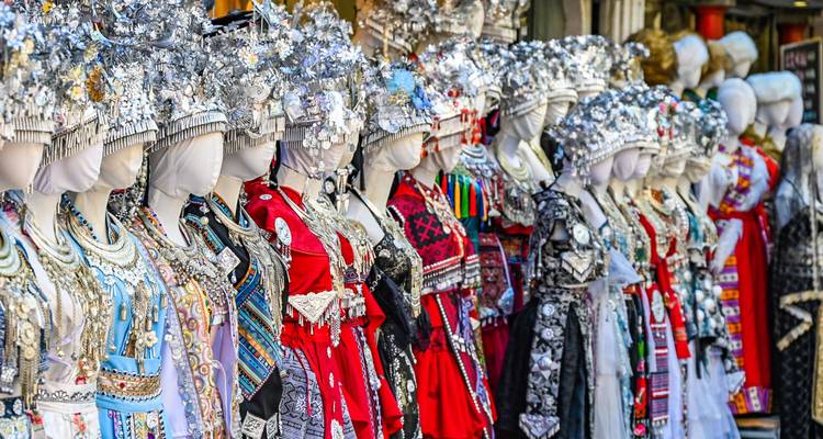Rij zonder kopf van etalagepoppen gekleed in sierlijke traditionele etnische kostuums met zilveren versiering