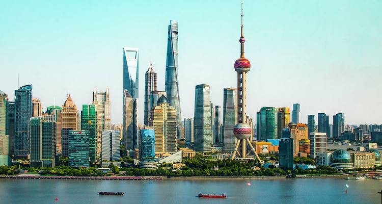 Moderne skyline van Shanghais Pudongwijk met het iconische Oriental Pearl Tower aan de overkant van de Huangpu River