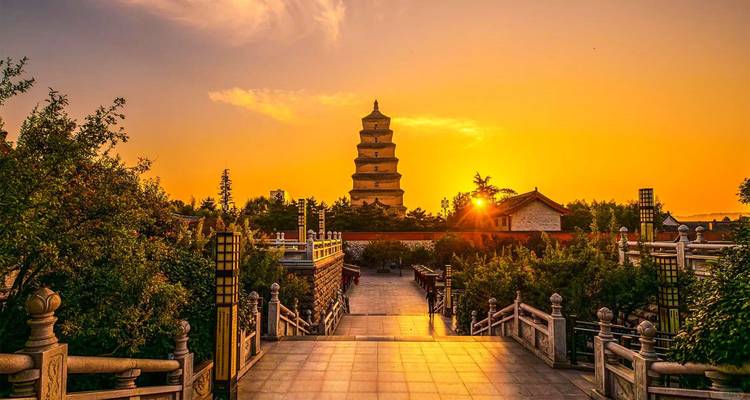Silhouet van Big Wild Goose Pagoda bij zonsondergang met gouden lucht en voorgrond brug