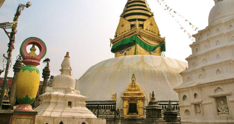 Stupa mit Gebetsfahnen und klarem Himmel.