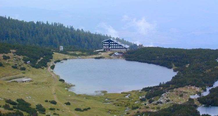 Lac avec un bâtiment dans un paysage luxuriant.