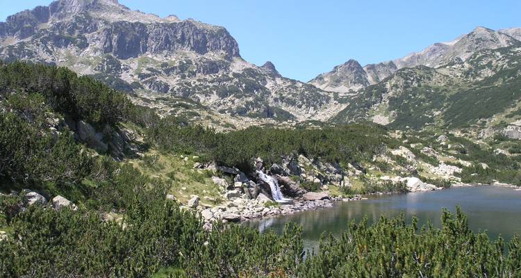 Paysage de montagne avec une petite cascade et un lac.