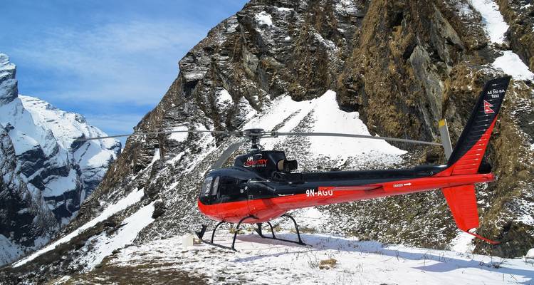 Helicóptero estacionado en una zona montañosa nevada.