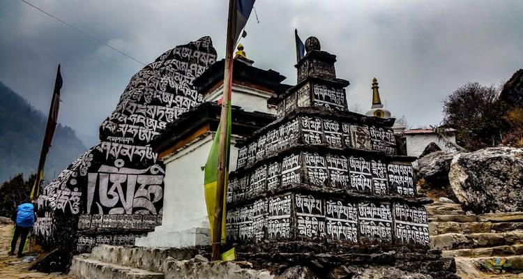 Prayer stones and stupa with mountains in the background.